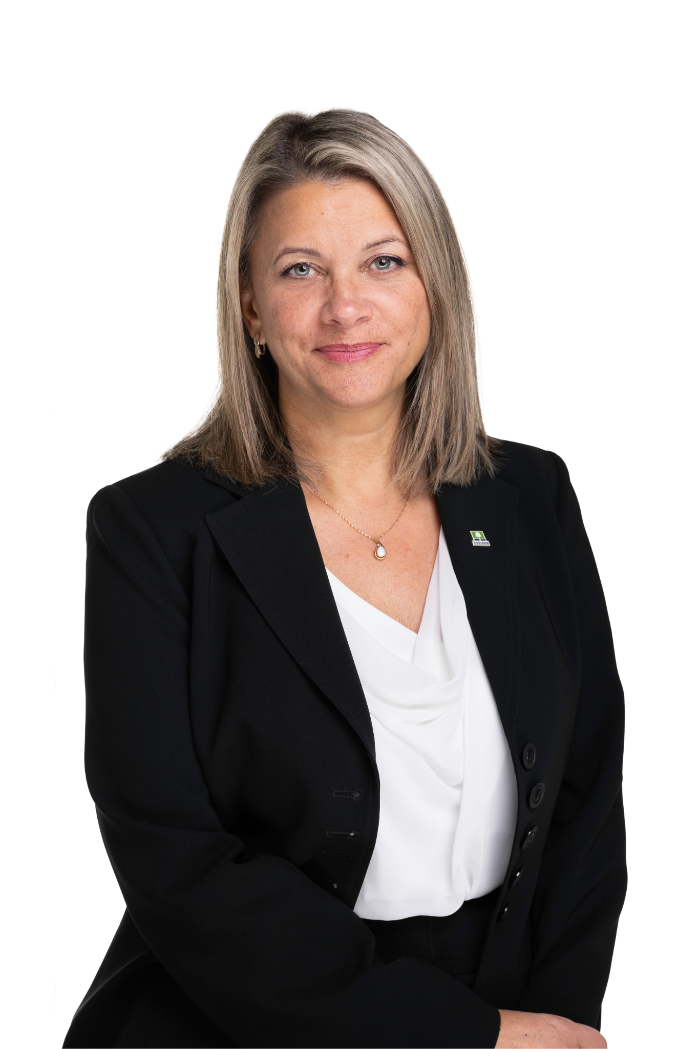 Une femme d'affaires portant un costume noir et un chemisier blanc, avec un fond blanc.