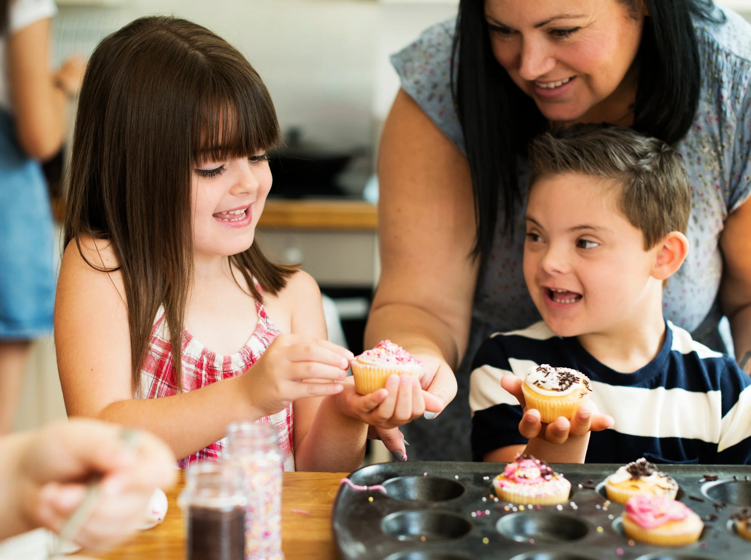 This image is of a family baking together, smiling and learning from each other.