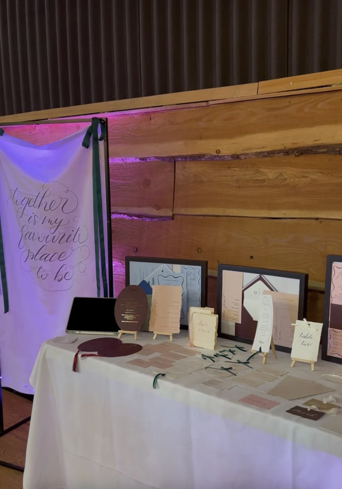 a close up shot of the stationery showcase table and a clear view of a fabric banner written in calligraphy