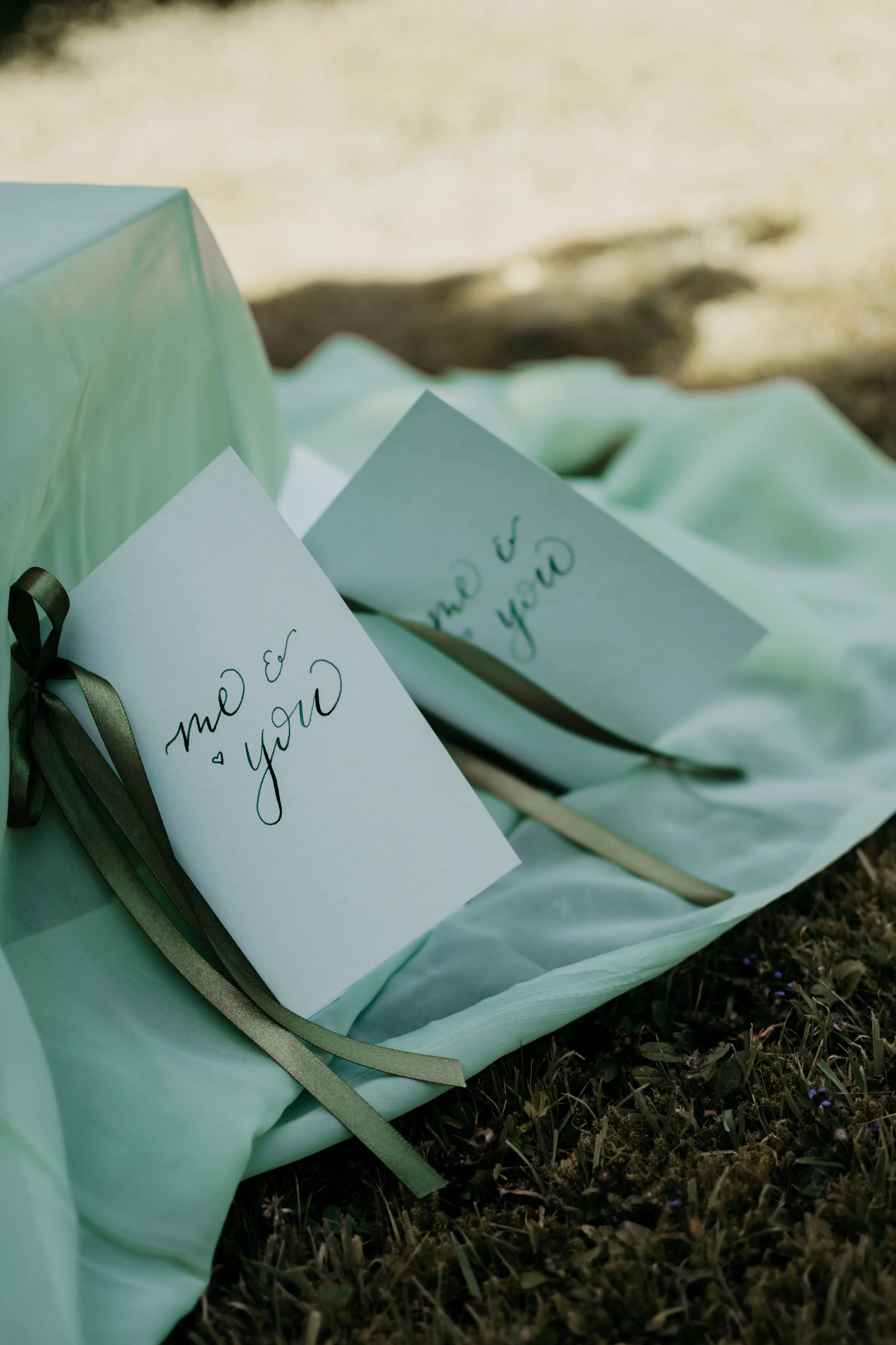 A pair of green vow books with green ribbon and calligraphy