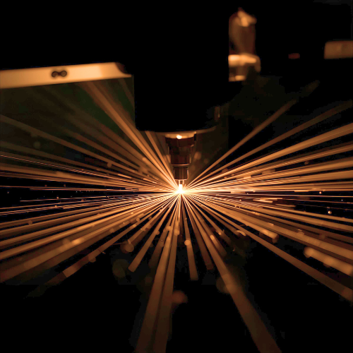 Close-up of a laser cutting machine cutting metal, with sparks flying outward.