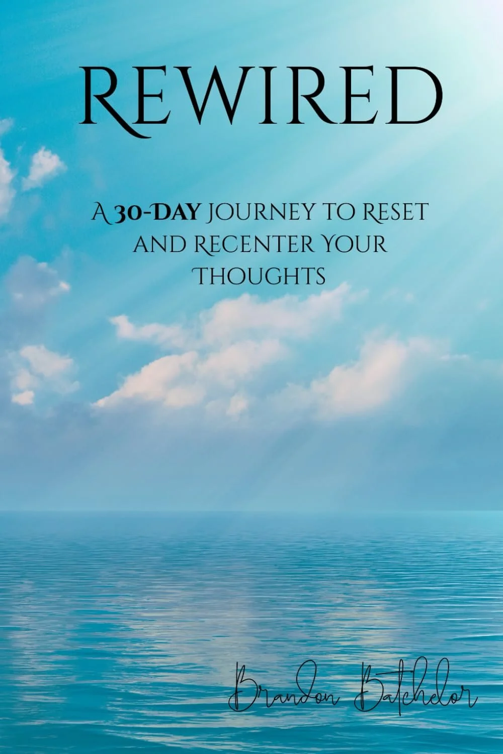 Cover of a book titled 'Rewired: A 30-day journey to reset and recenter your thoughts' by Brandon Bachelder, featuring a serene blue sky with clouds and a calm ocean.