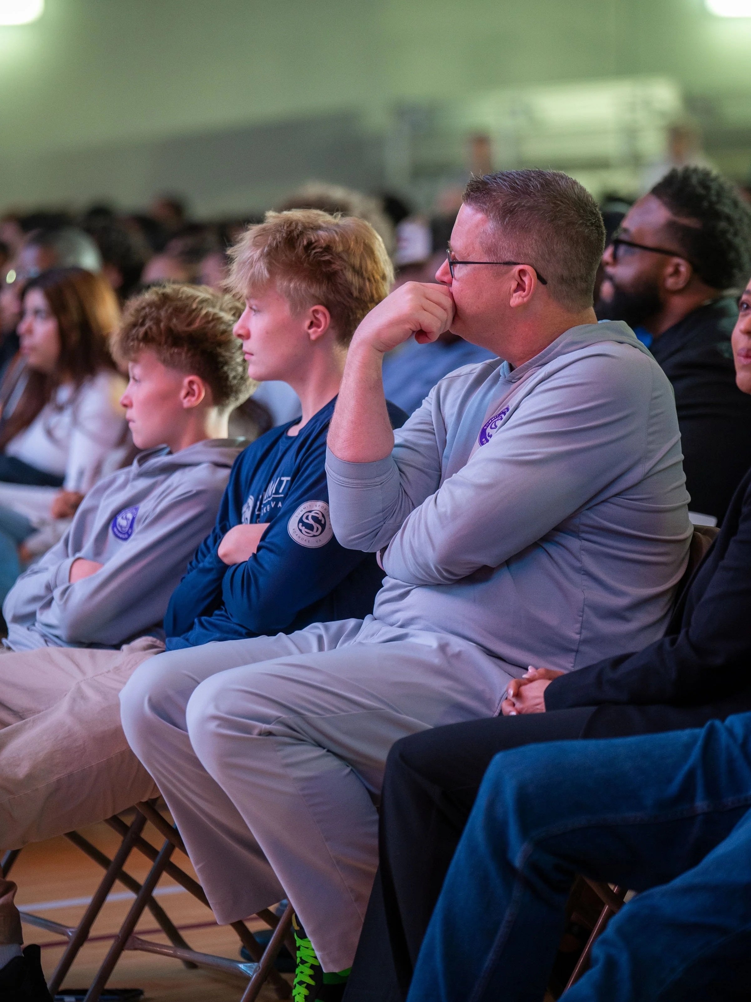 Kevin Connelly sits with his sons in the audience as Ray Lewis speaks at Summit Sportsplex in Roanoke, VA during a community event for local student athletes.