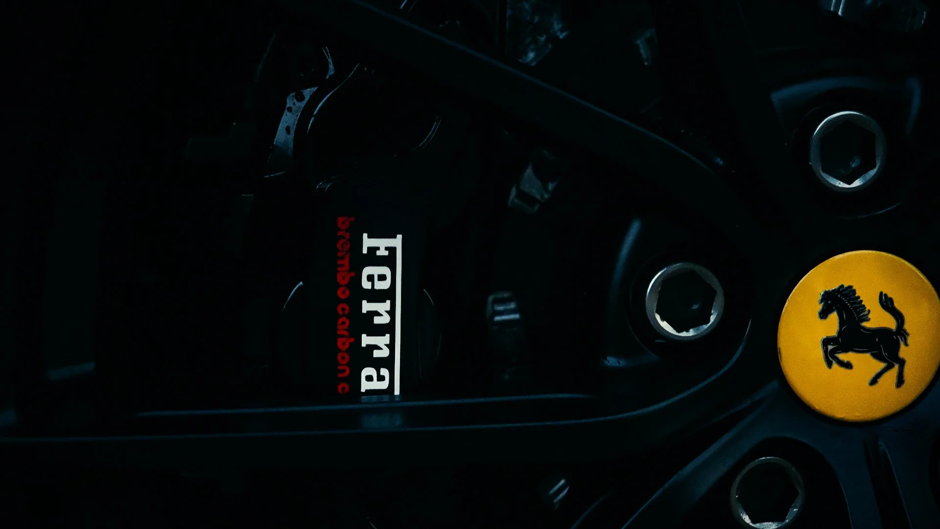 Close-up of a Ferrari steering wheel with a Ferrari logo and a sticker reading 'Ferrari' and 'begins with C' on the center cap.