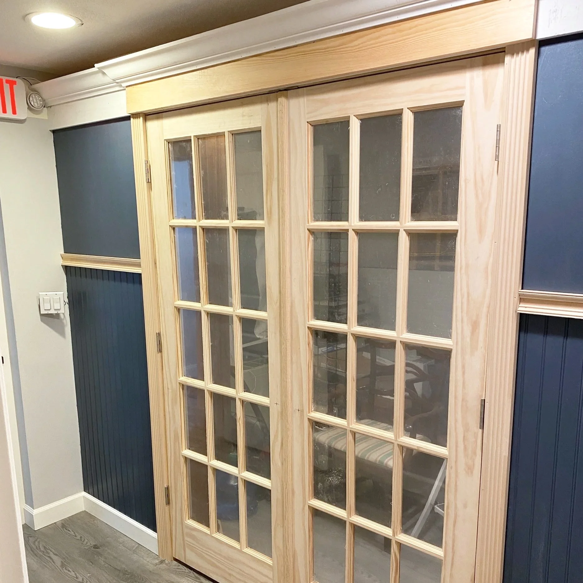 Glass-paneled double doors with light wood frames in an interior setting.