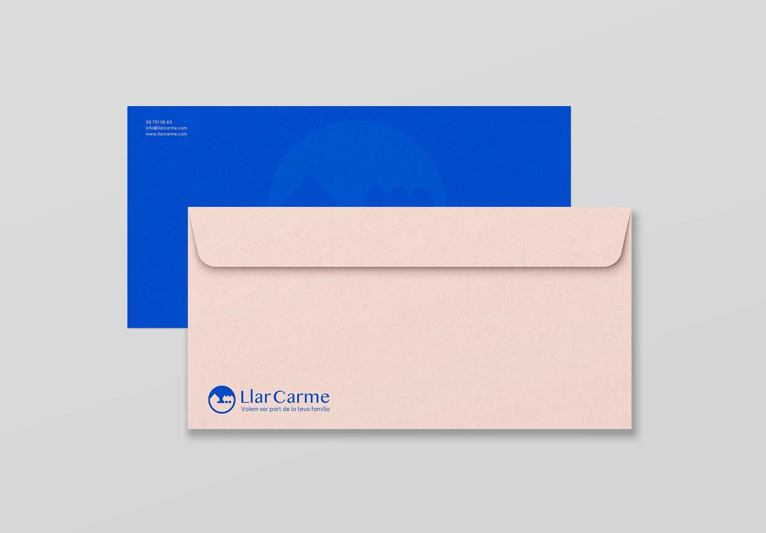 Sobres y carta de la empresa Llar Carme en colores rosa y azul, con logo y contacto en la esquina inferior izquierda del sobre rosa_Llar carme_premia de mar_diseño identidad de estudio berlin