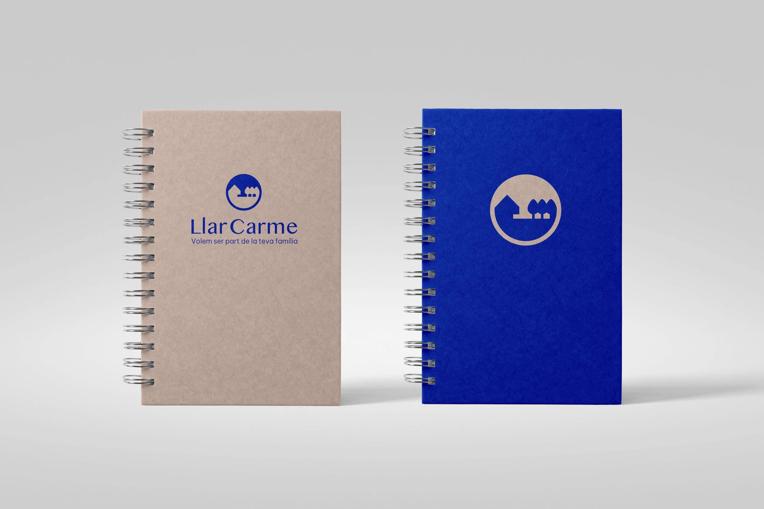 Dos cuadernos con logotipos y texto en la portada, uno beige y otro azul_Llar carme_premia de mar_diseño identidad de estudio berlin