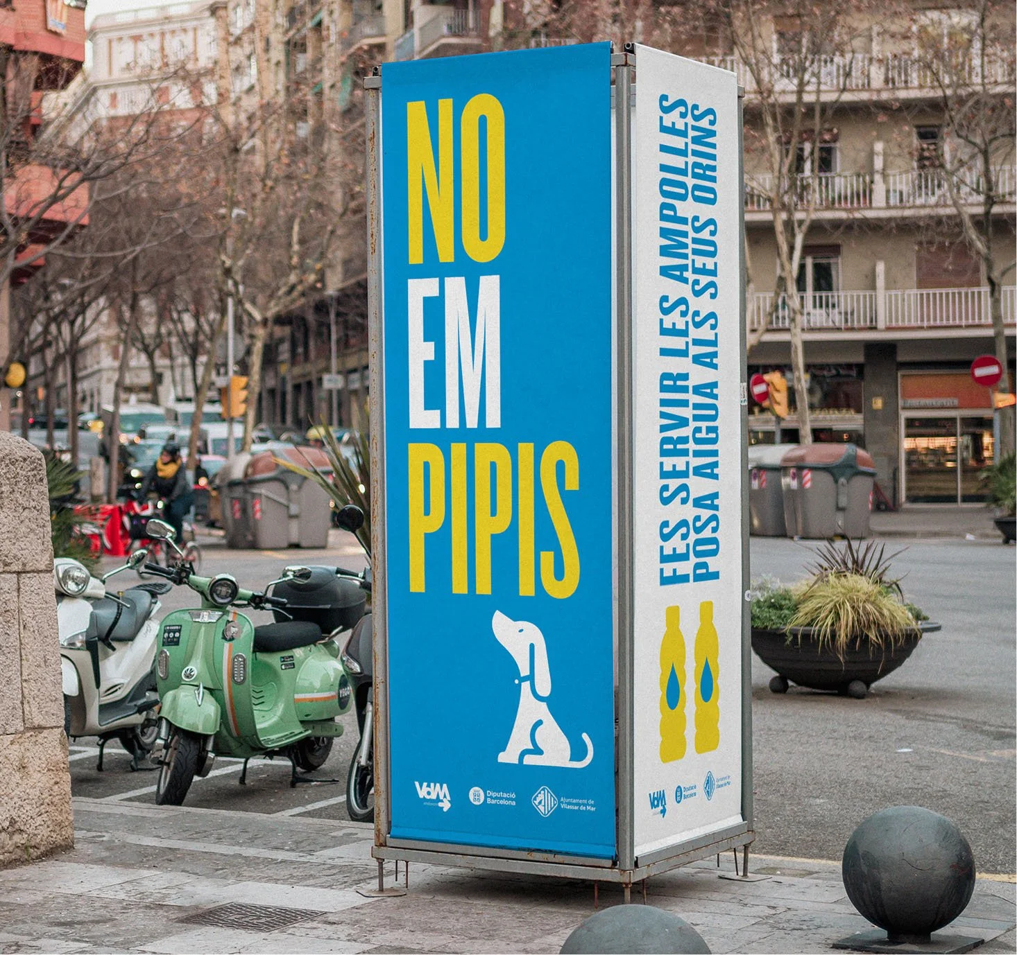 Cartel que dice 'No em pipis' con una ilustración de un perro y un mensaje en el lado que indica que está prohibido orinar en la fuente de la plaza, en contra de hacerlo con agua en las botellas.