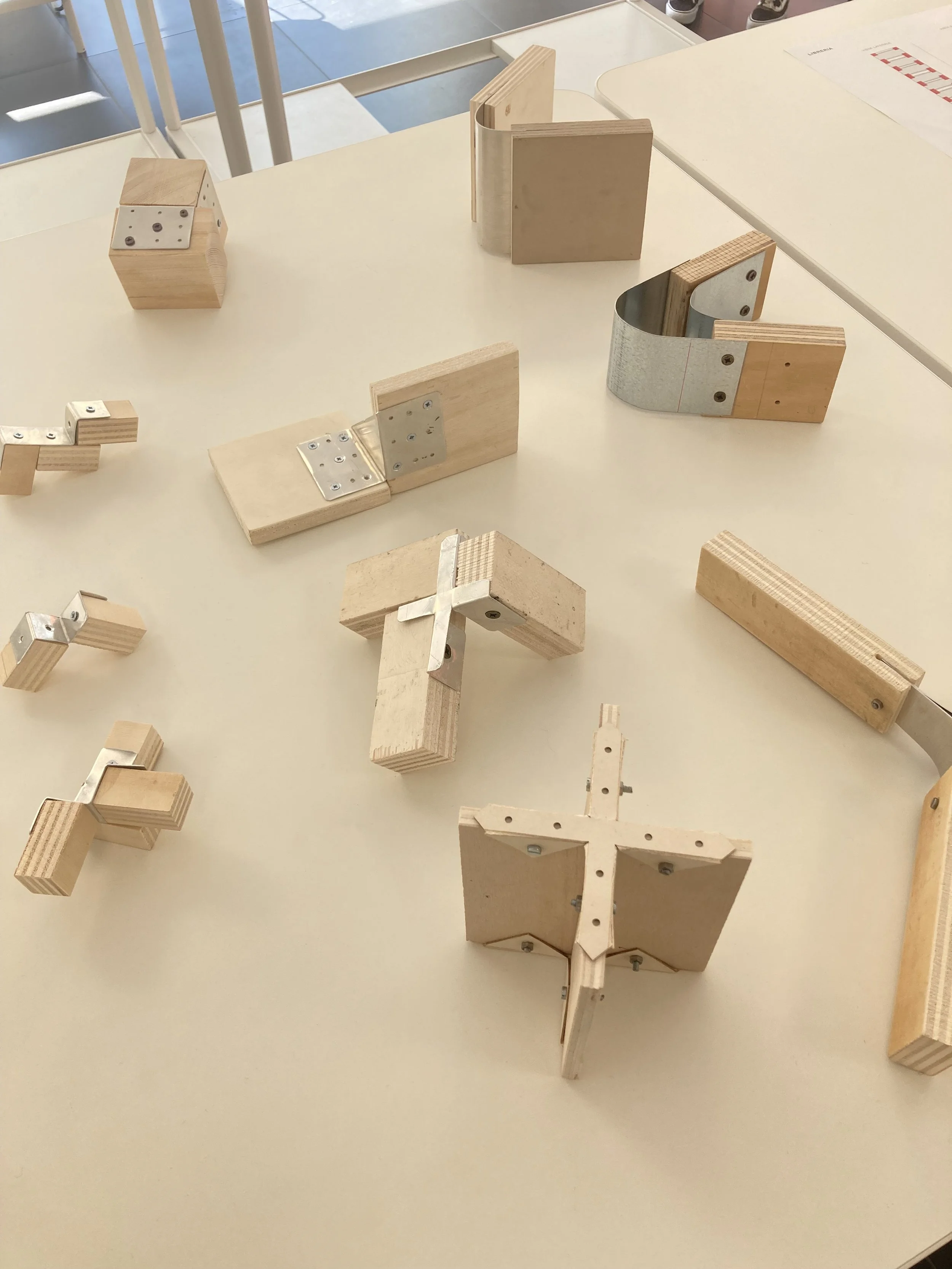 Modelli di strutture in legno assemblate con piastre e cerniere e viti.