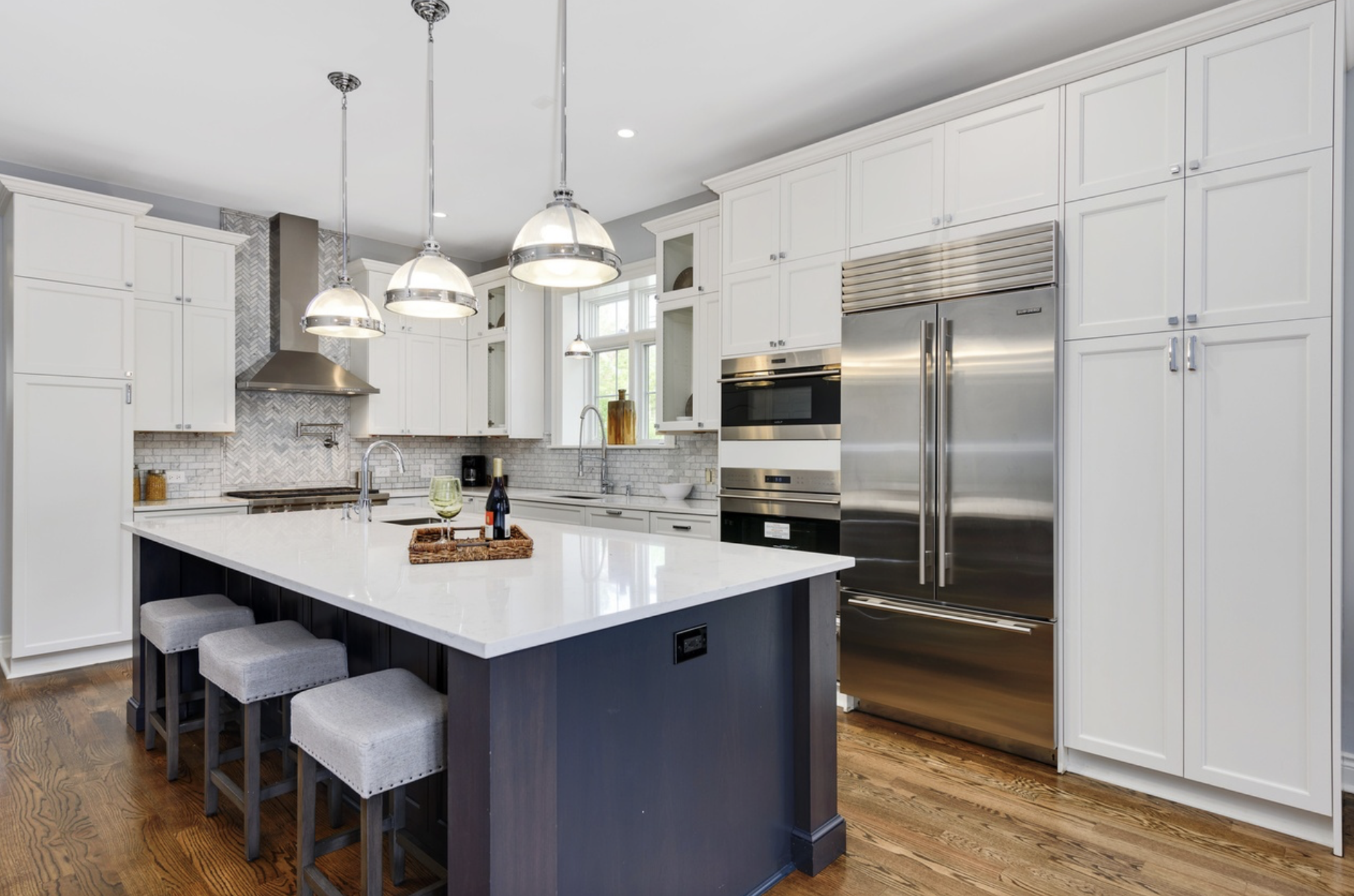 Luxury chef's kitchen remodeled by Accent Construction & Remodeling in Lincoln Park, Chicago with custom cabinetry, quartz countertops, workstation sink, natural stone, and a large island.