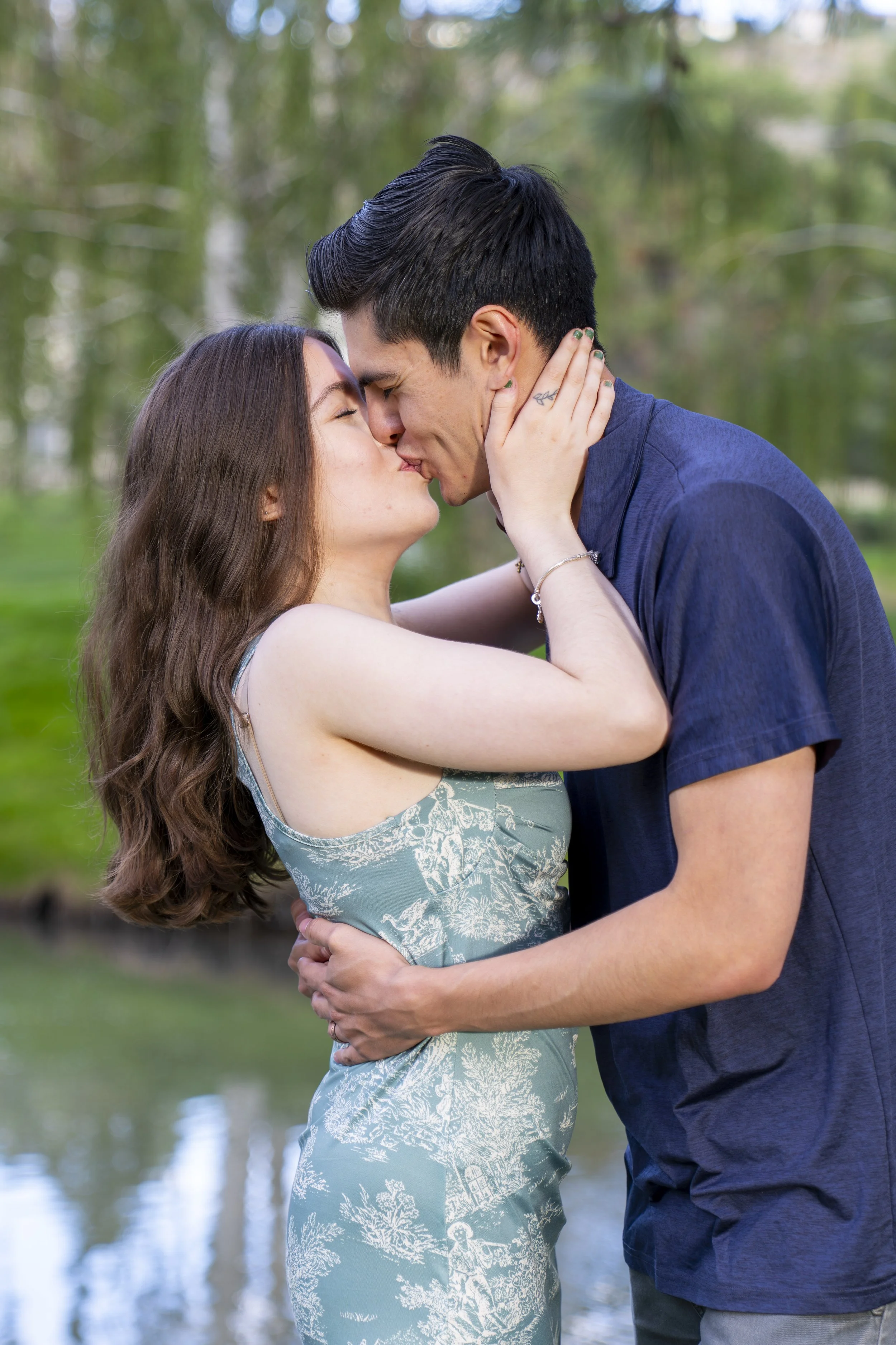 A young couple share a kiss during an engagement photoshoot.