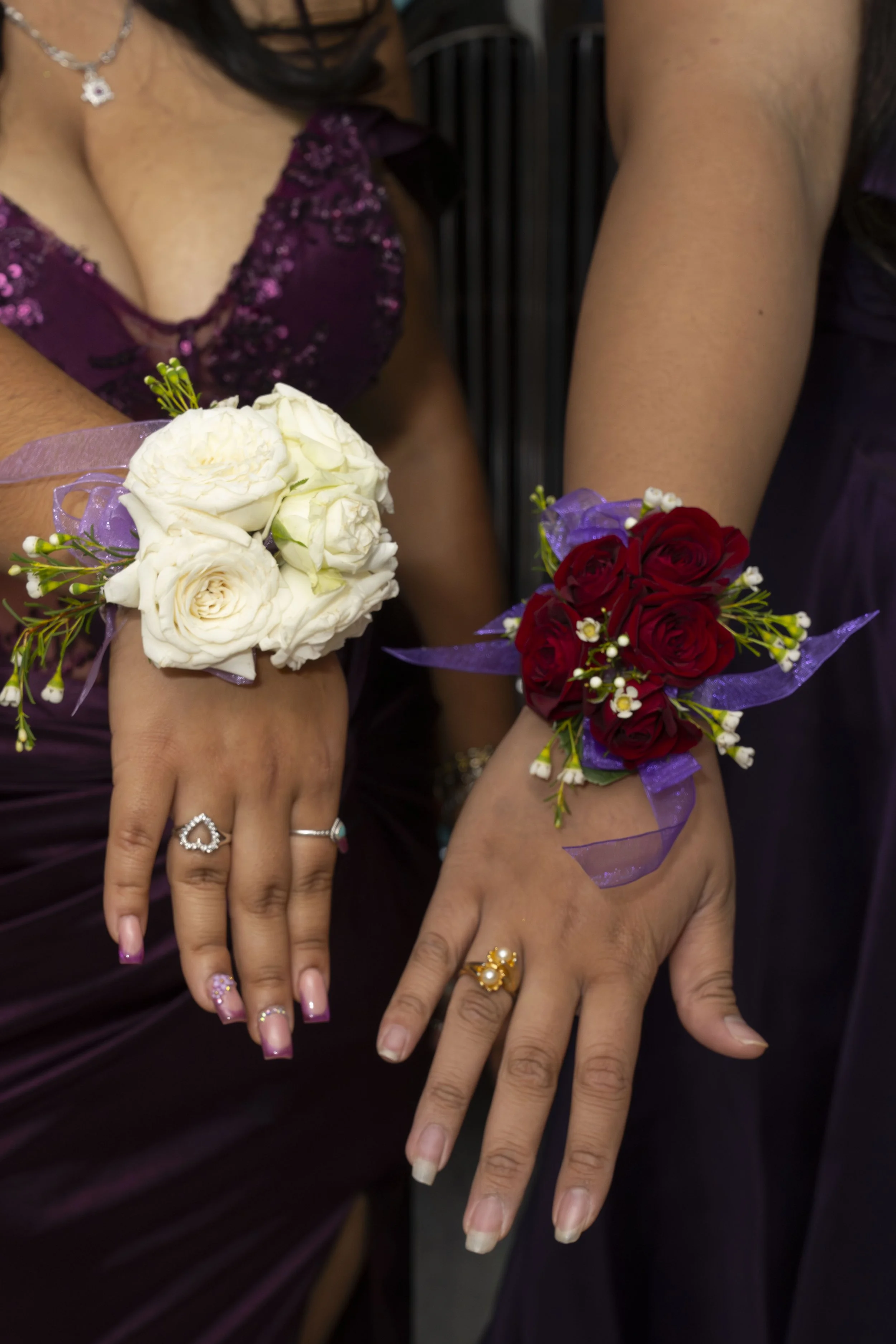 Two ladies showcase their corsages during their prom event.