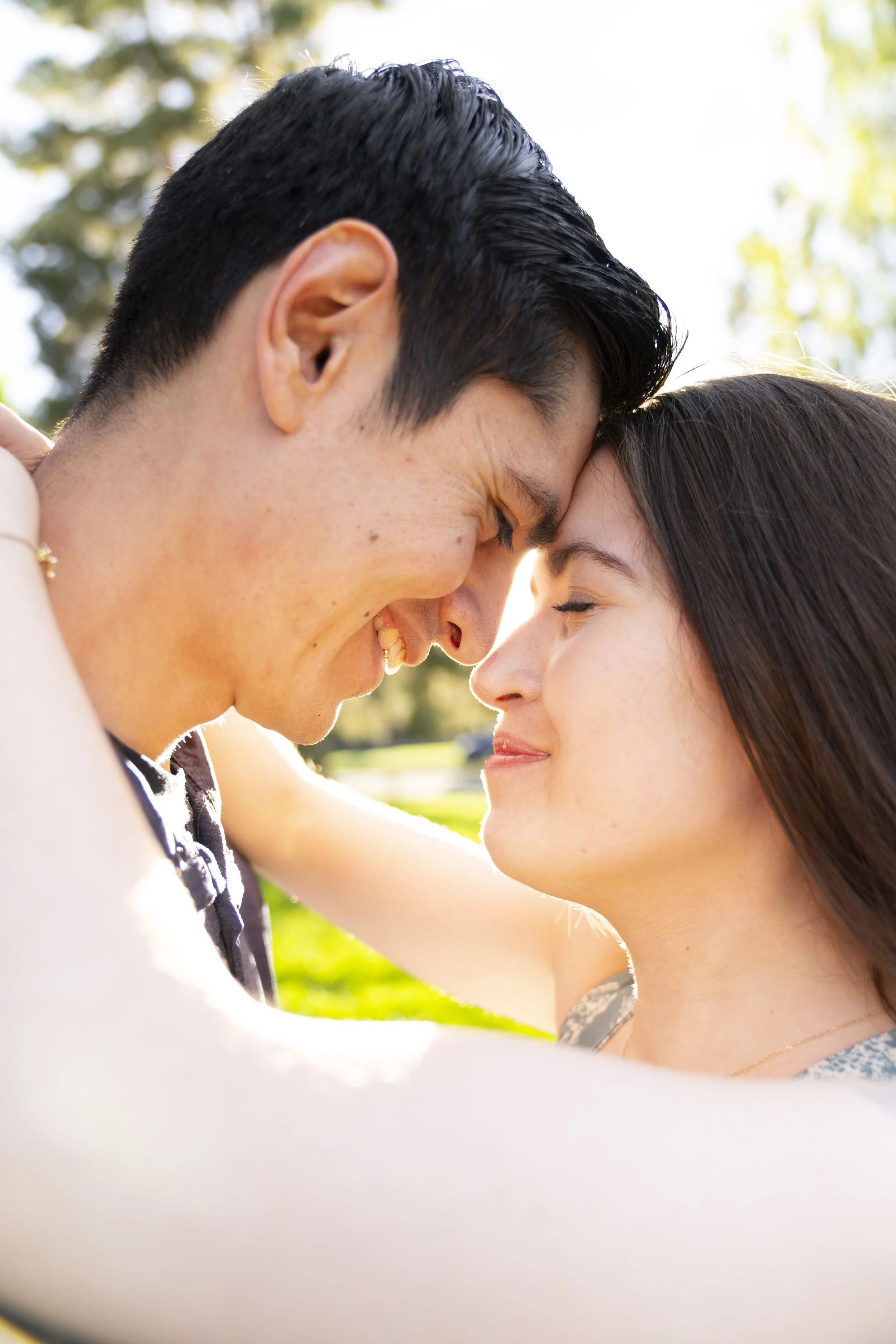 A young couple embraces each other for an engagement photoshoot.