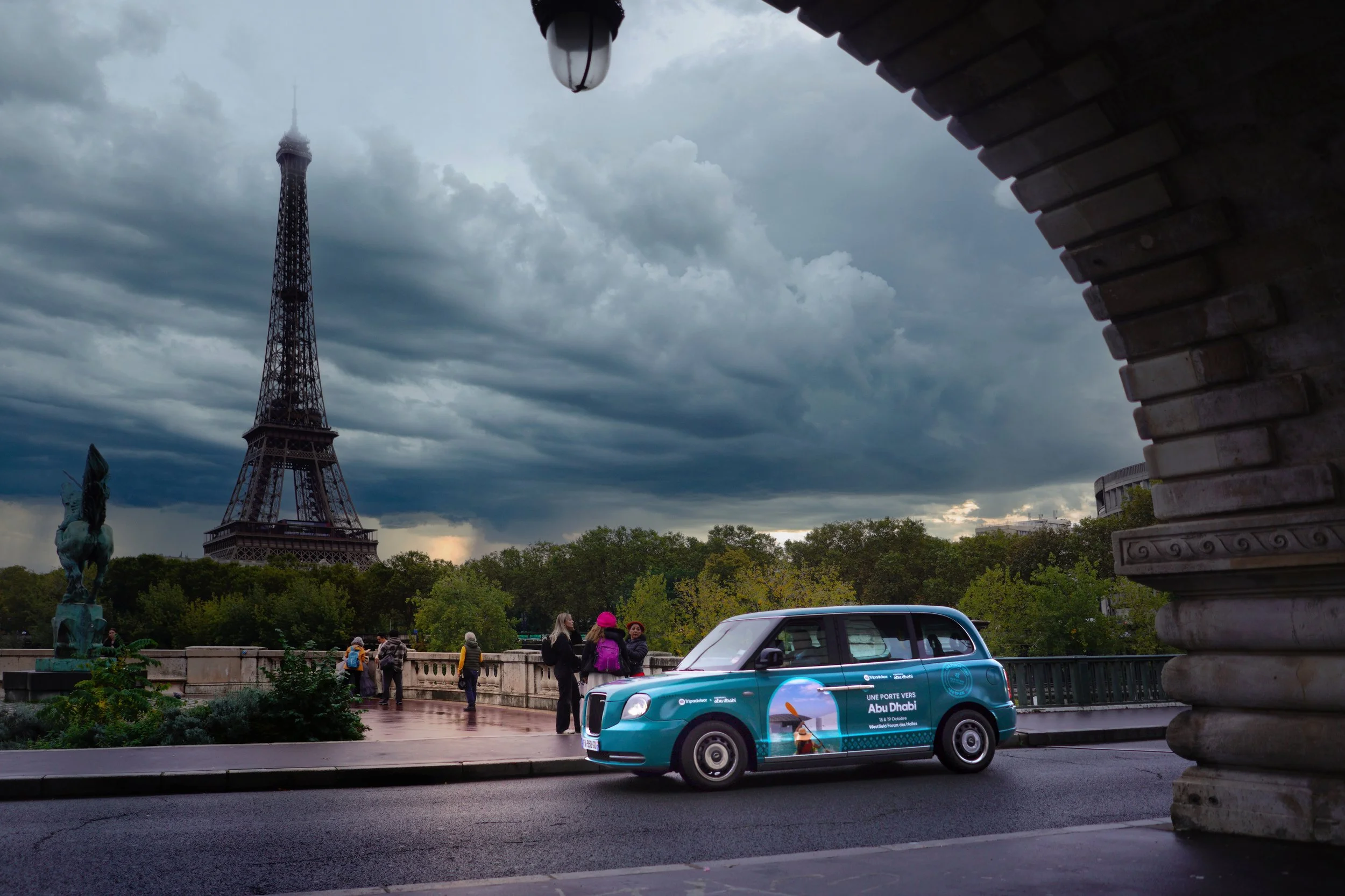 Advertising on the side of a teal taxi in Paris