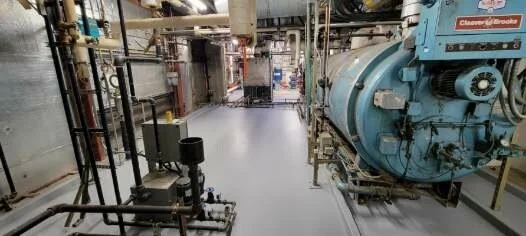 Industrial boiler room with pipes and machinery.