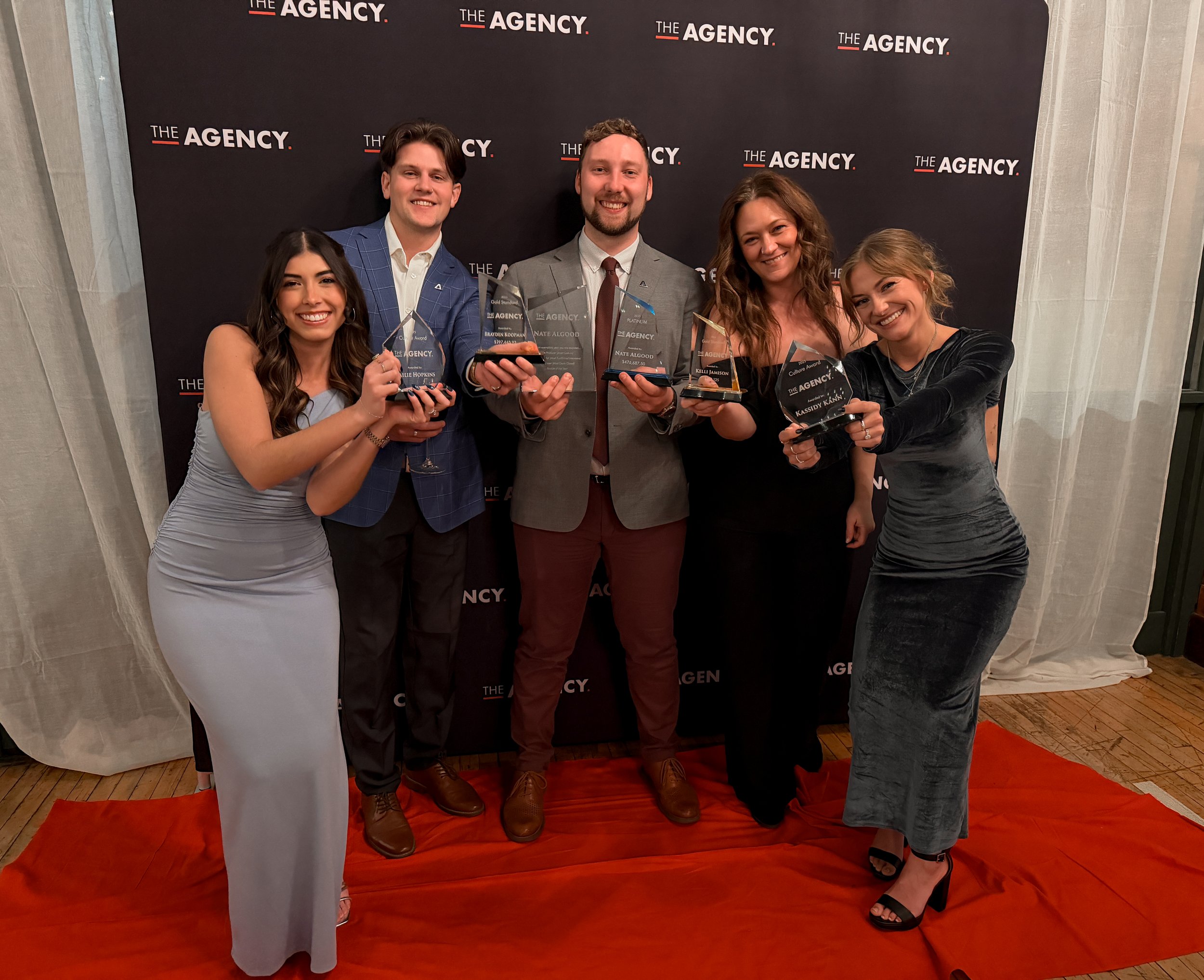 Coworkers posing for a photo with awards