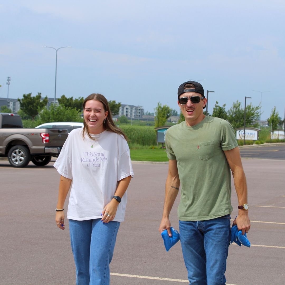 Two employees laughing and playing yard games