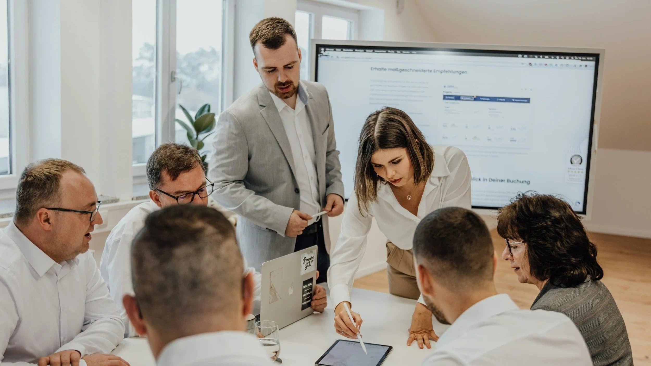 A diverse team of professionals working together in an office, illustrating the collaboration and alignment required for high employee engagement.