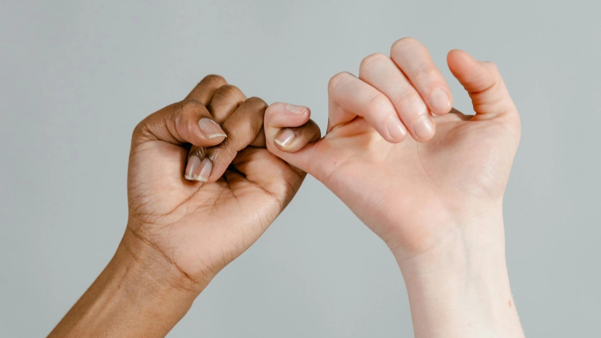 A close-up of a pinky promise gesture symbolizing trust, personal integrity, and keeping commitments in business