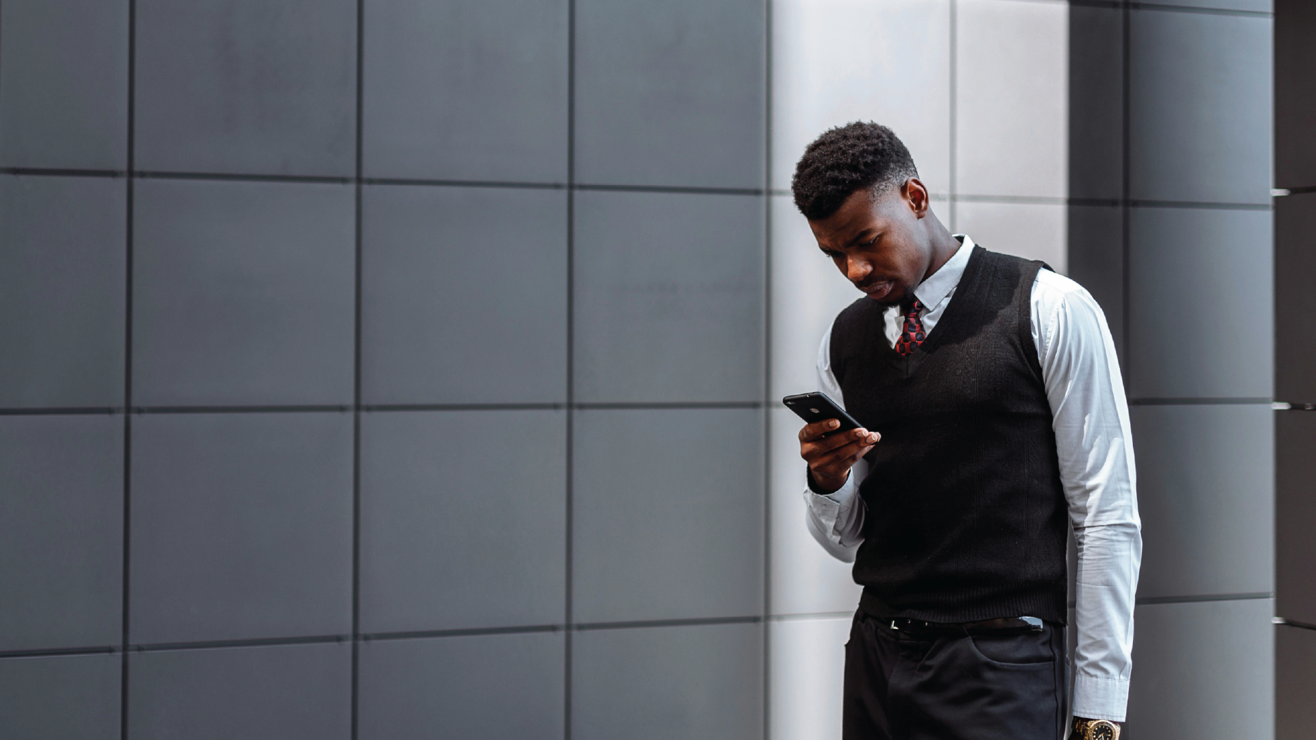 A businessman checking his phone during a work break, representing the intentionality and strategic reflection needed for long-term career stability.