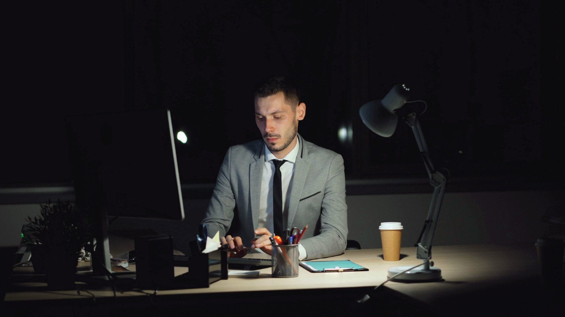 Frustrated employee experiencing job bait and switch at a desk due to hiring misalignment.