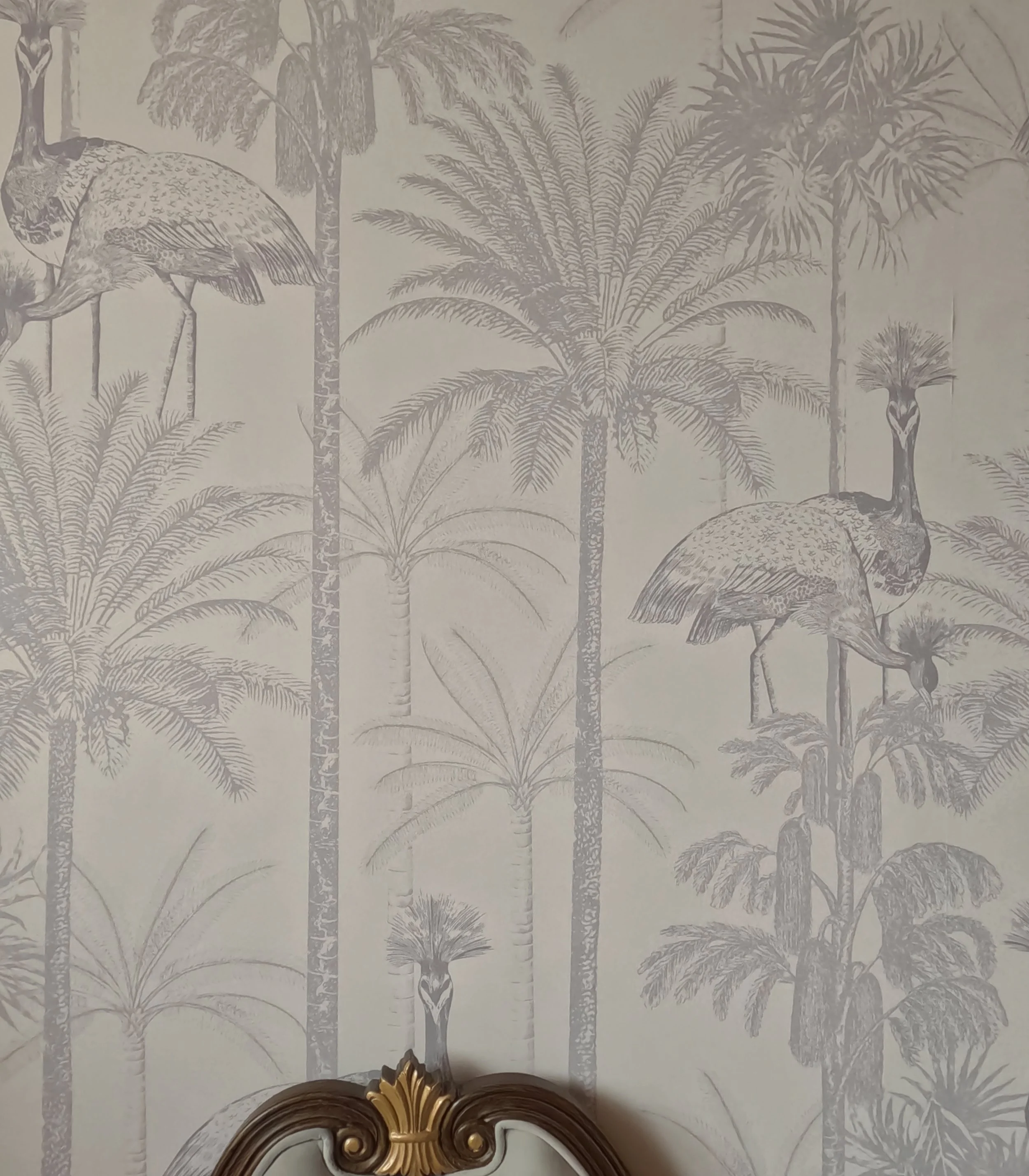 Wallpaper with a pattern of tropical trees and birds.