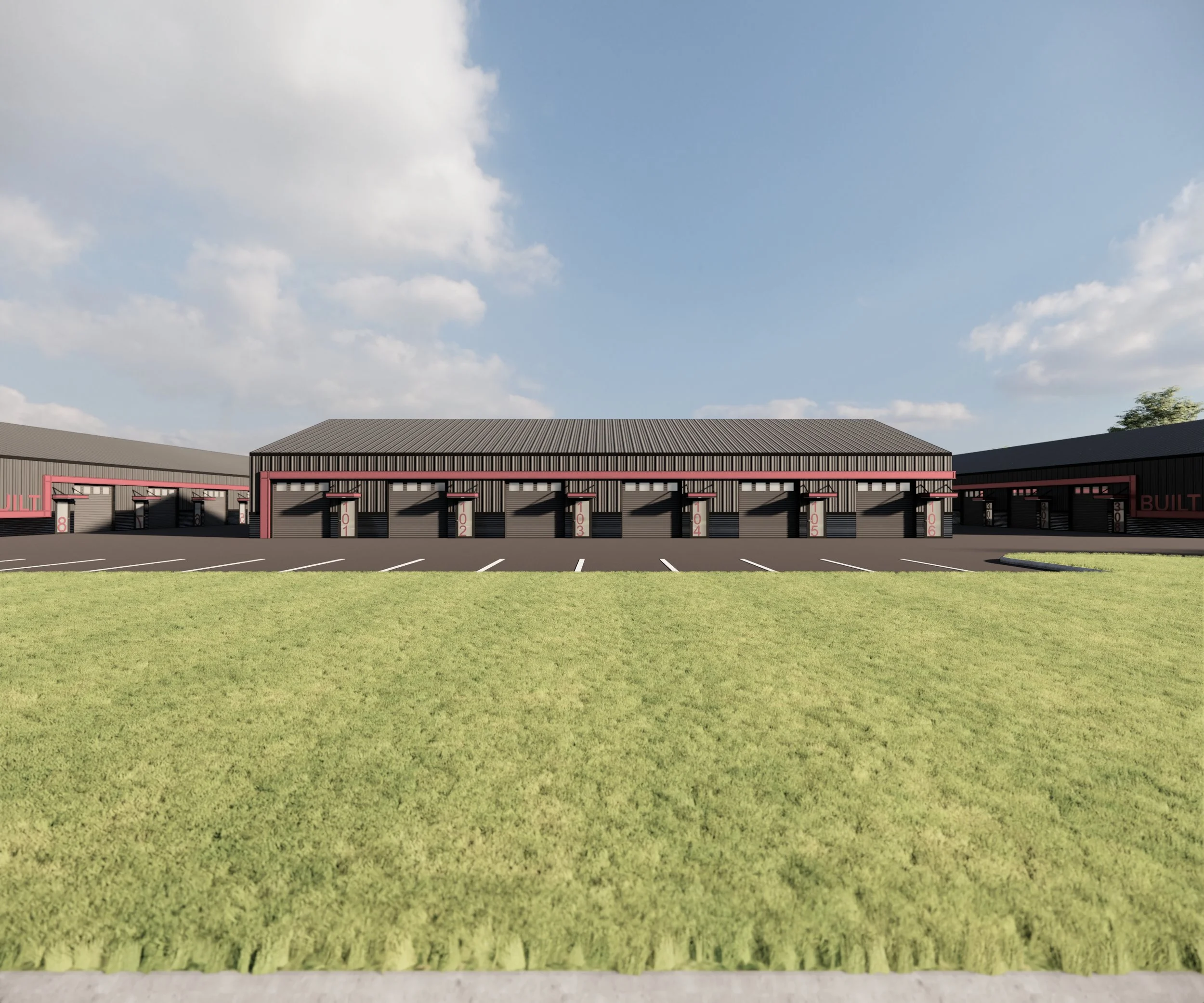 A row of modern storage units or garages with numbered doors, set in a building with black siding and pink accents. There are marked parking spaces in front and a grassy area in the foreground.