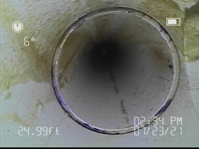Inside view of a pipe or tunnel with a rough, concrete exterior wall.