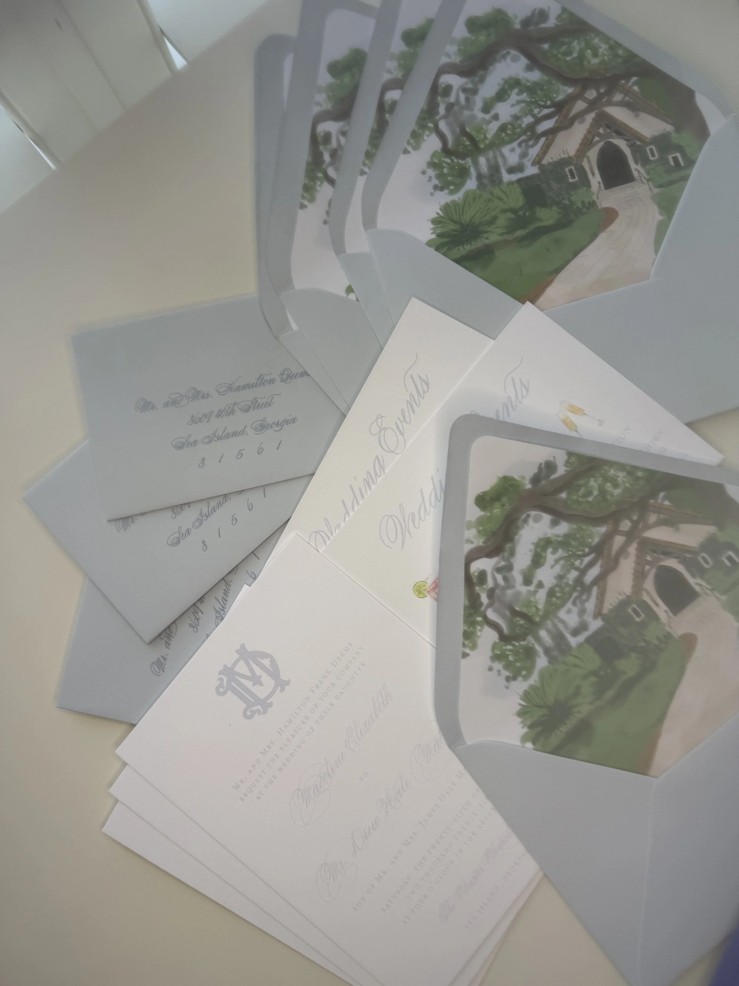 Sea Island Wedding Invitation Design with soft blues, a custom watercolor illustration of The Cloister Chapel lining the envelope, a custom letterpress invitation with monogram -- all of the things that make elevate a southern coastal wedding suite.