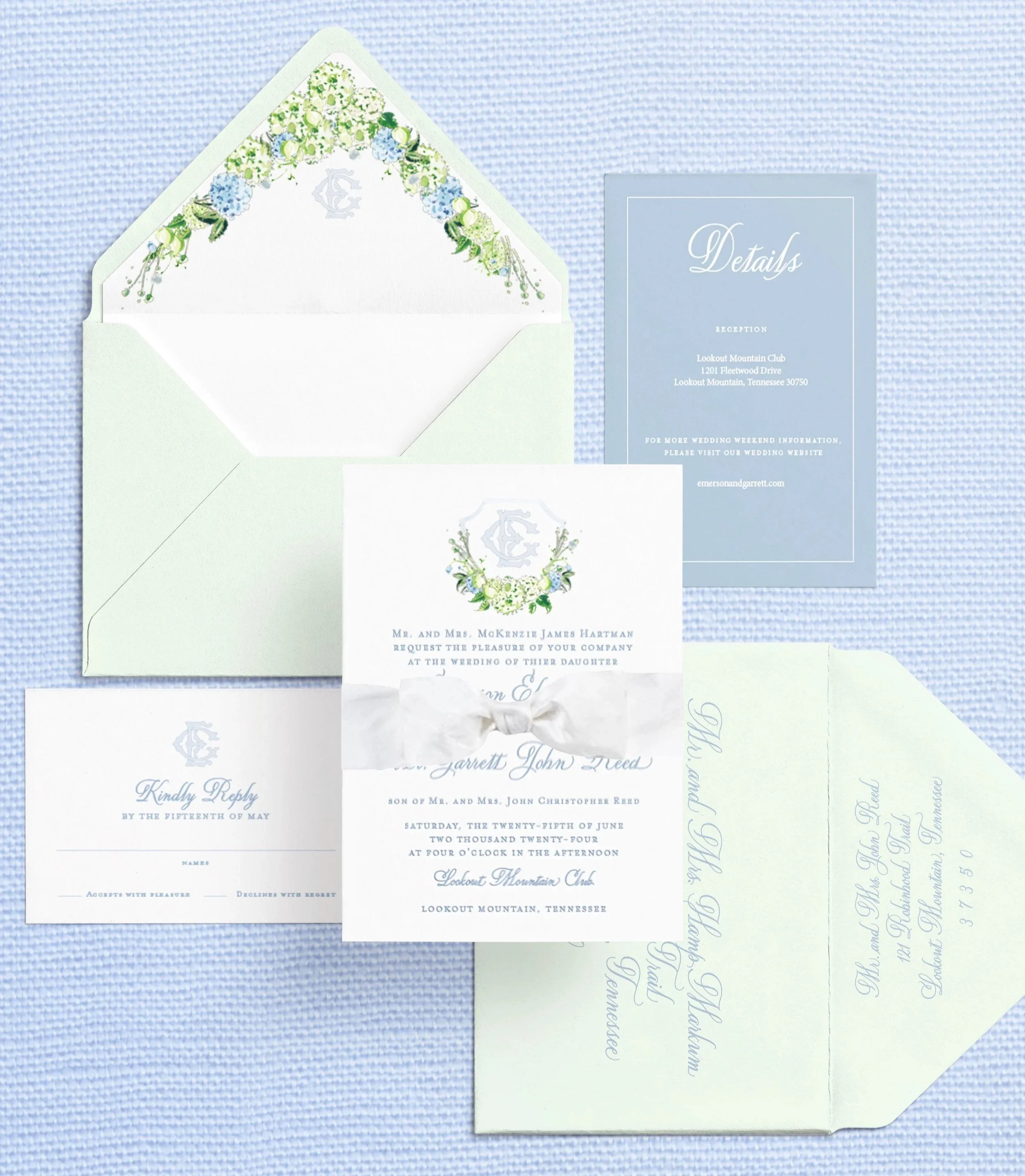 A set of wedding invitations, RSVP card, and details card with light blue and white floral designs on a light blue textured background.