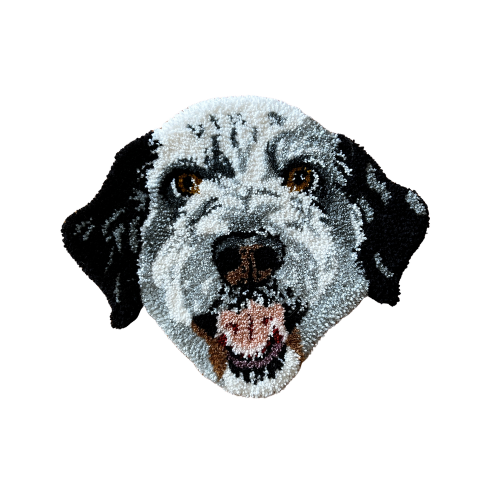 A plush rug in the shape of a dog's face, possibly an Australian Shepherd, with black and white fur and light brown eyes.