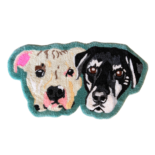 A plush rug shaped like two dogs, one light-colored with a pink nose and one black with a white face, side by side.