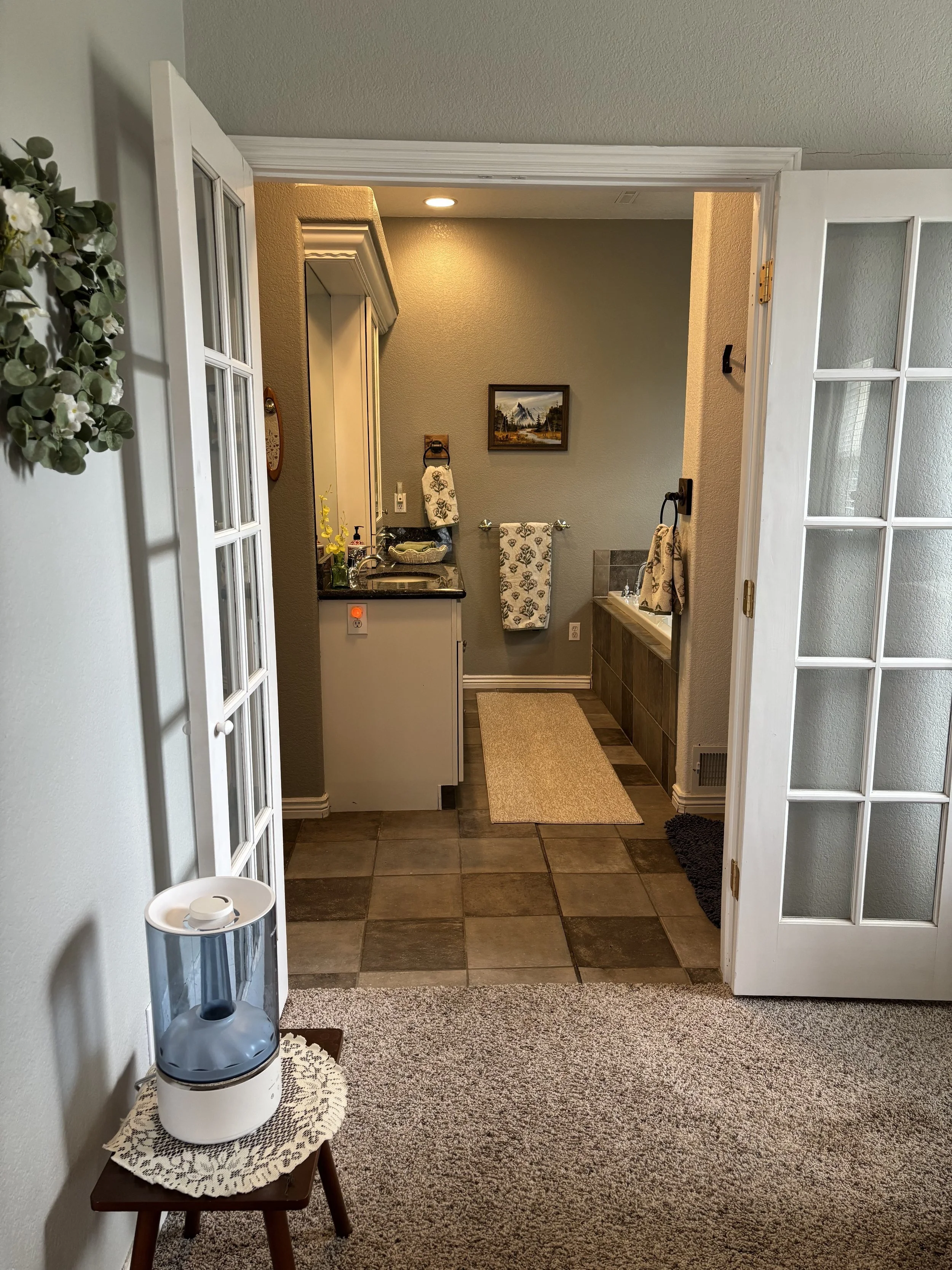 Master bathroom with double sinks, shower, and bath