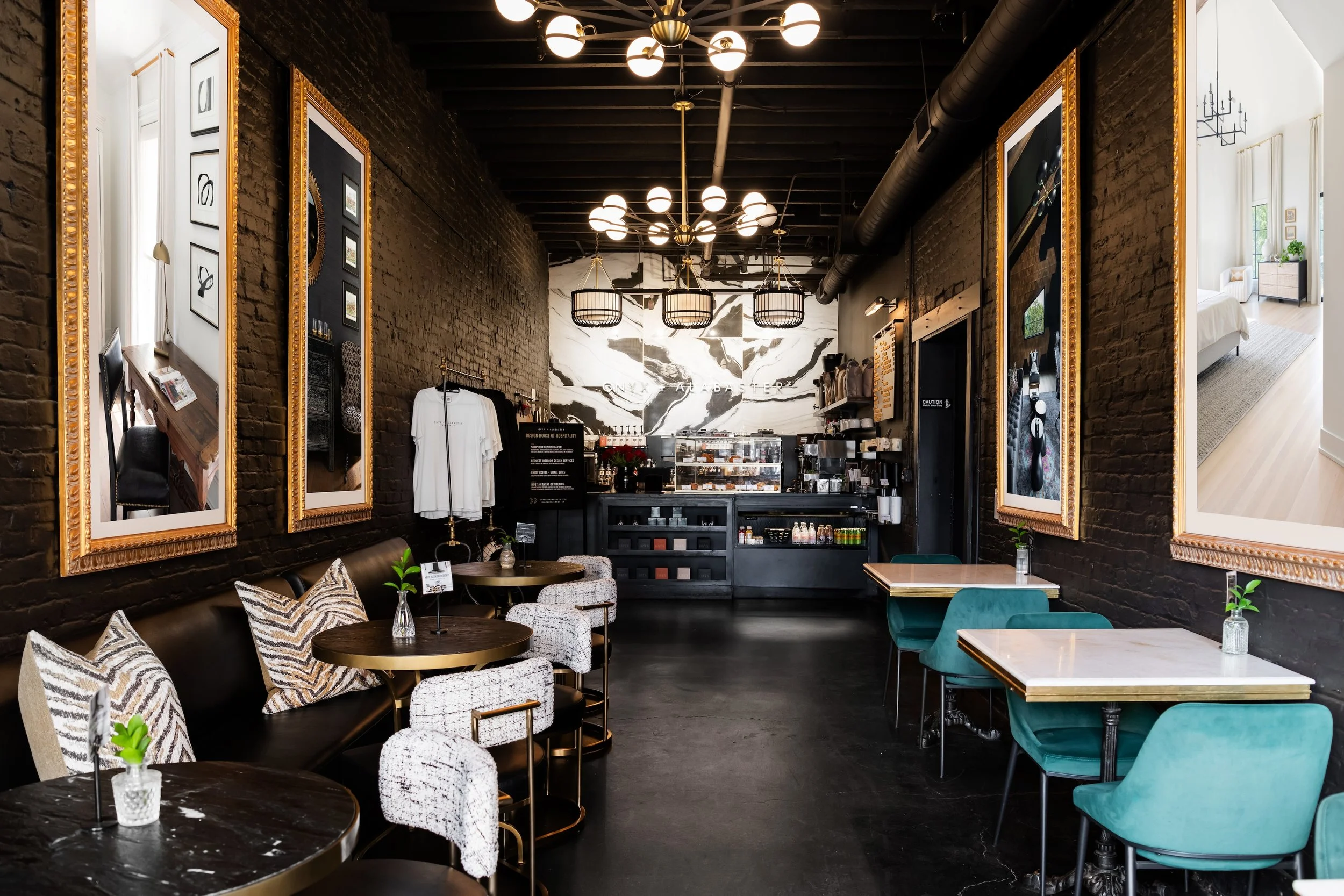 Black modern Interior of The Coffee Lounge at Onyx and Alabaster with upholstered seating, overhead chandeliers, and framed interior design artwork on the walls in downtown Franklin, Tennessee