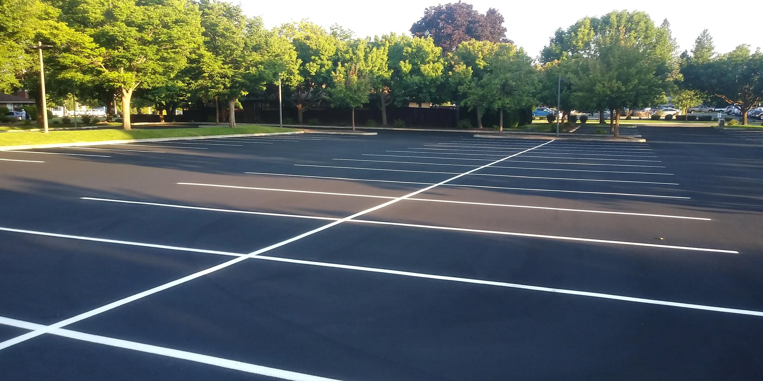 Empty parking lot with new black asphalt, white painted parking lines
