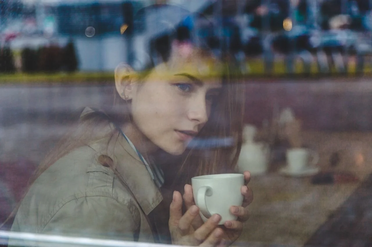 woman-in-brown-coat-holding-a-white-ceramic-mug