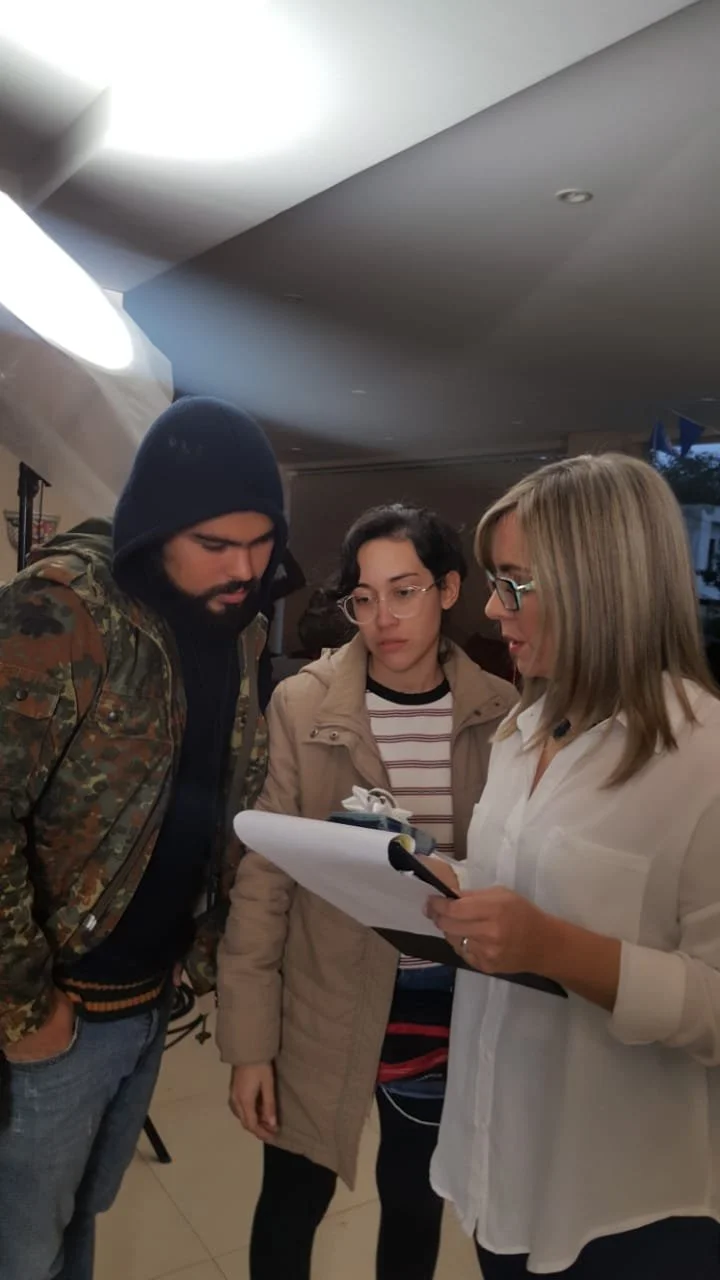 Tres personas adultas revisando documentos en un ambiente interior.
