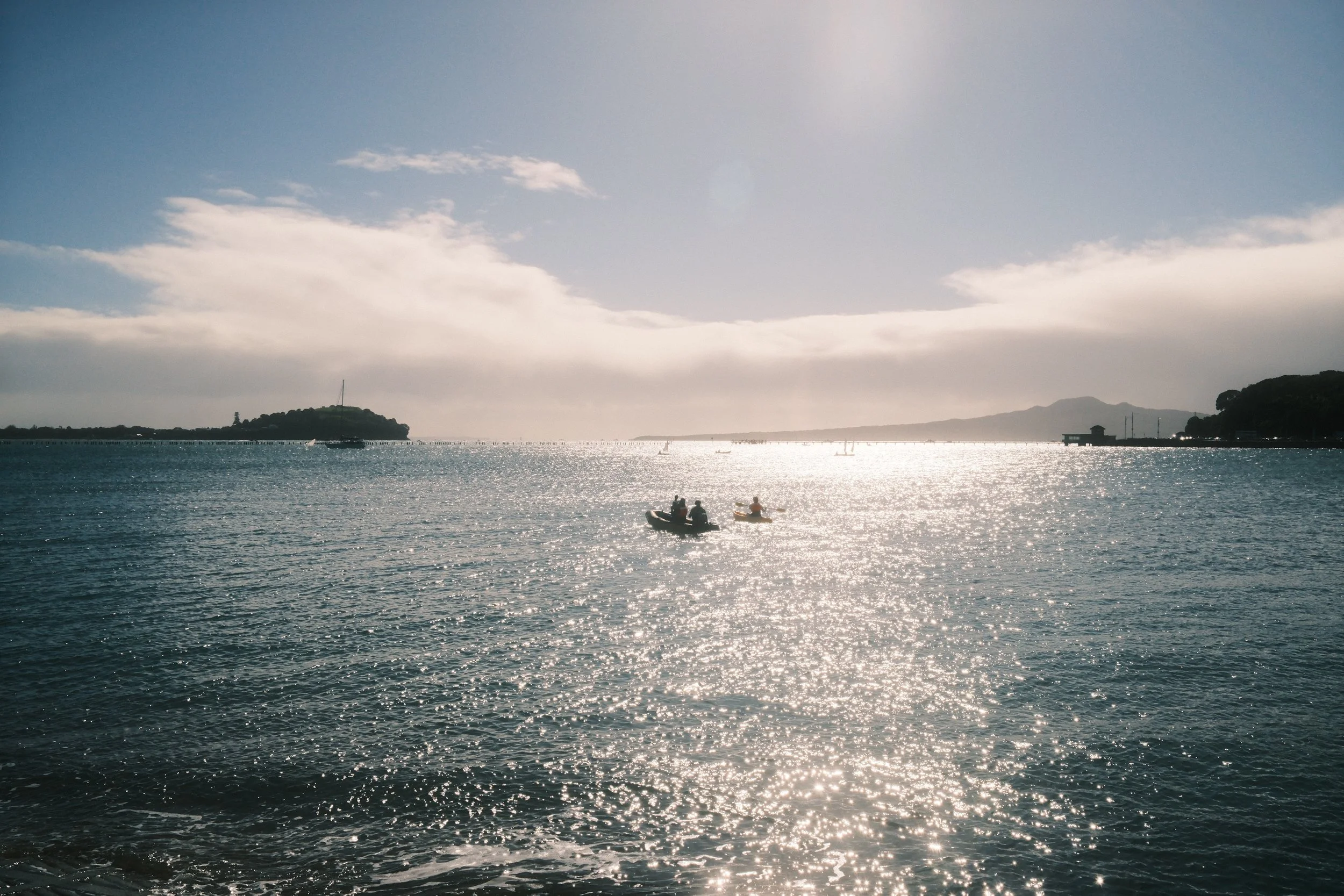 A scenic view of a body of water with small sailboats and kayaks, taken by Lemon Time Studios during the filming of a short.