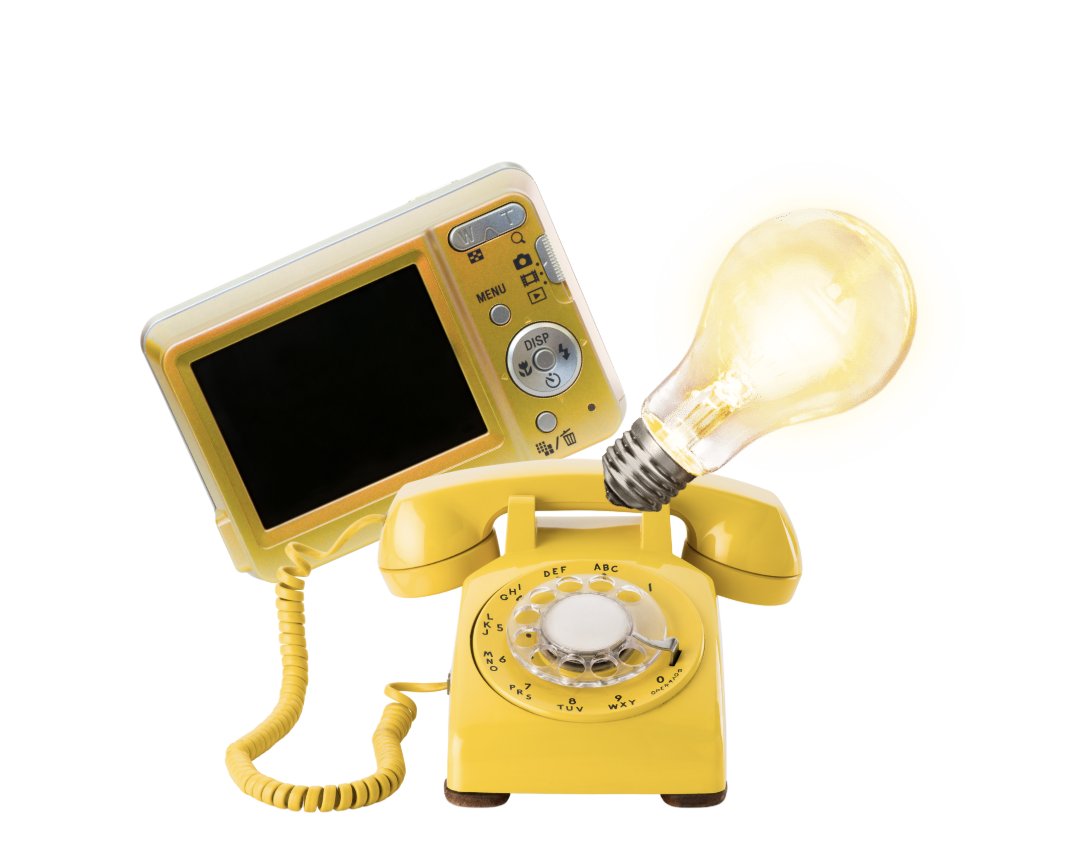A yellow rotary telephone with a vintage design, a connected yellow cord, a large light bulb standing on its socket, and a small digital camera with a yellow casing, set against a white background.
