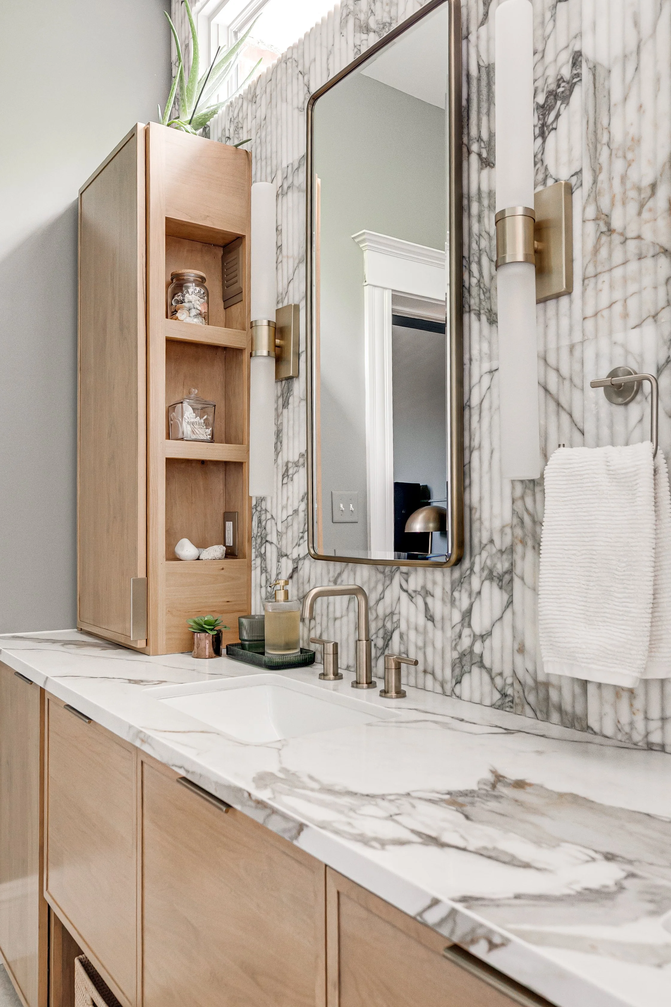 Custom vanity with fluted marble wall.jpg