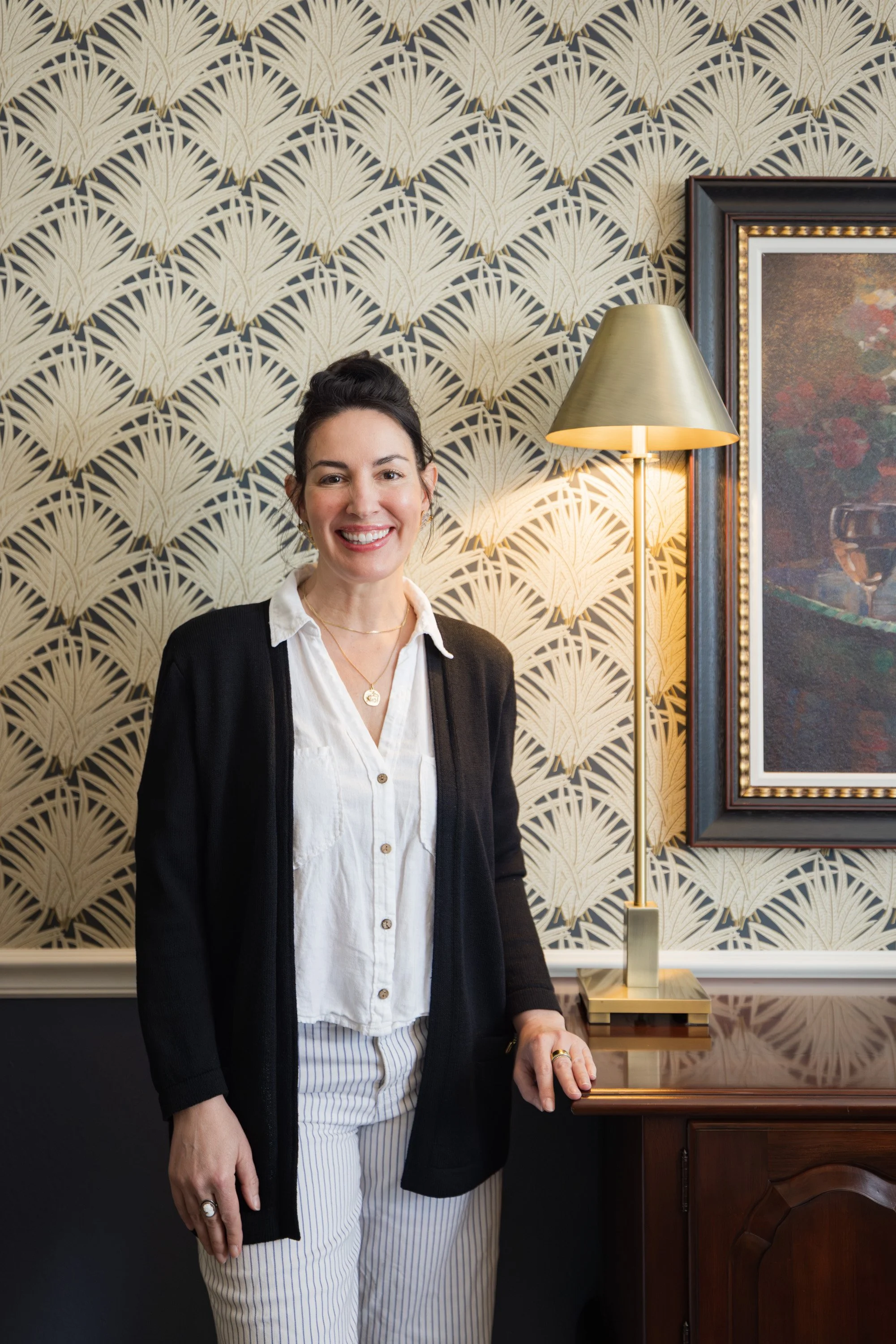 Refinement standing against pampas grass wallpaper in traditional dining room with brass light fixture