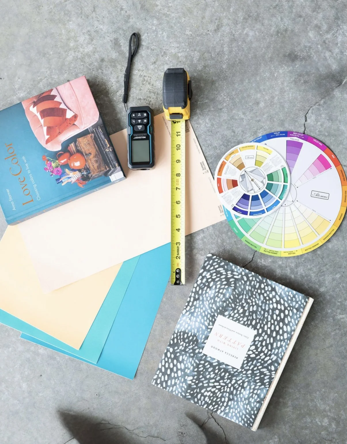 color book, tape measure and design tools on the concrete ground