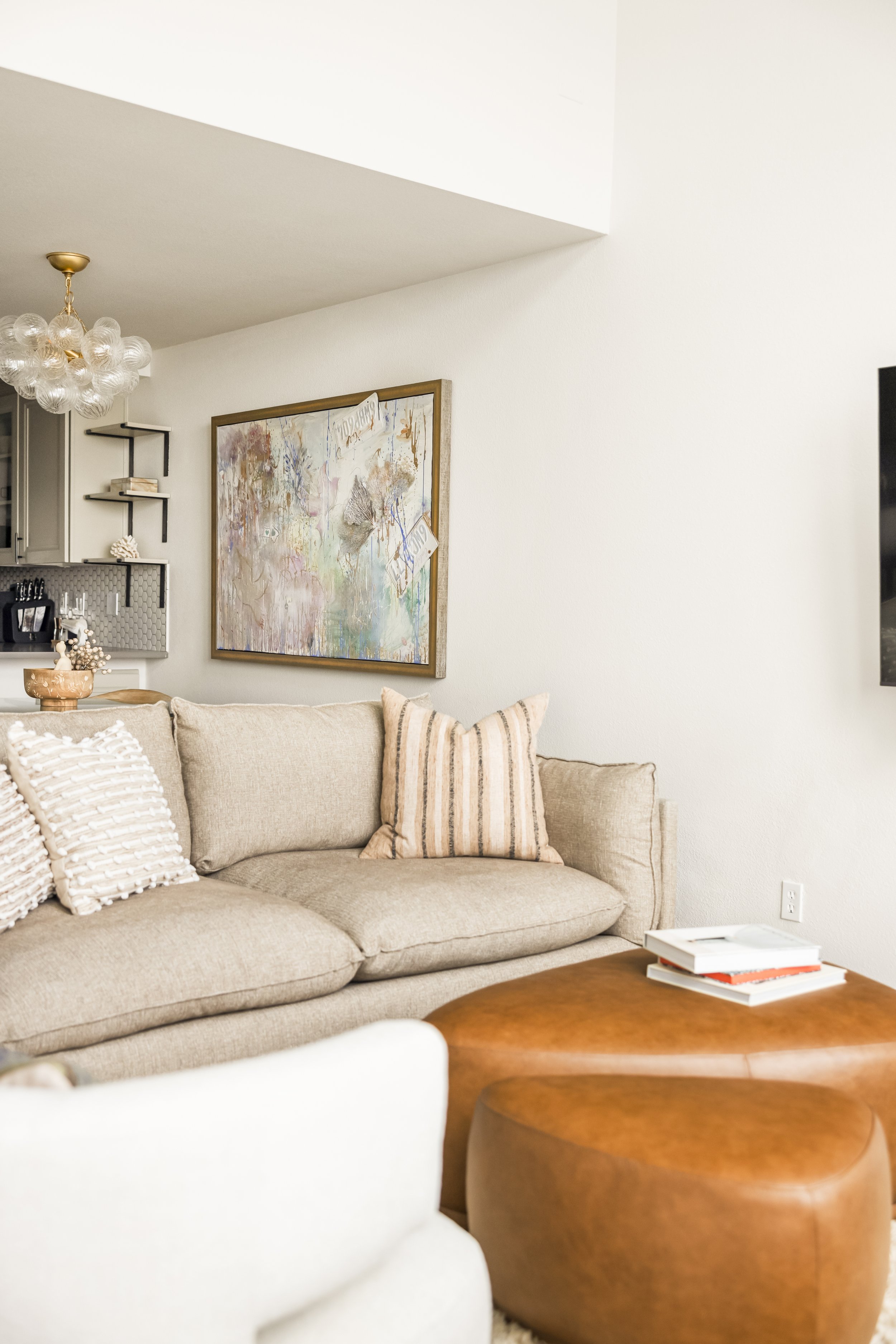 Living room with linen sofa, cognac leather ottoman, abstract art and bubble chandelier, Vancouver WA interior design