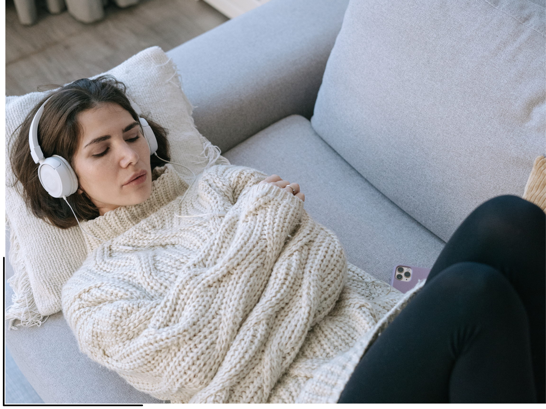 Woman laying on couch with headphones experiencing a ketamine-assisted psychotherapy session.