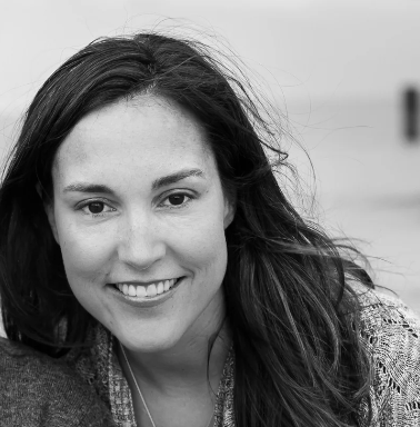 black and white photo of a woman smiling with wind blowing through her hair