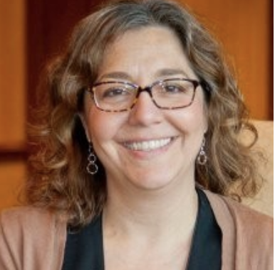 woman with wavy hair and glasses with a beautiful smile