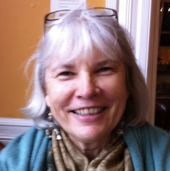 Older woman in her 60's with glasses on her head with gray hair