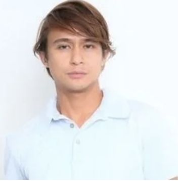 Man with light brown hair with a blue polo shirt posing for a head shot