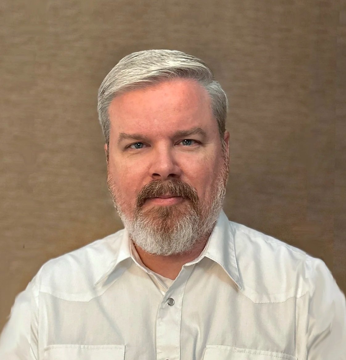 man with beard wearing a white western-style shirt