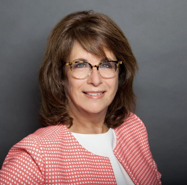 woman with brown shoulder length hair with glasses smiling